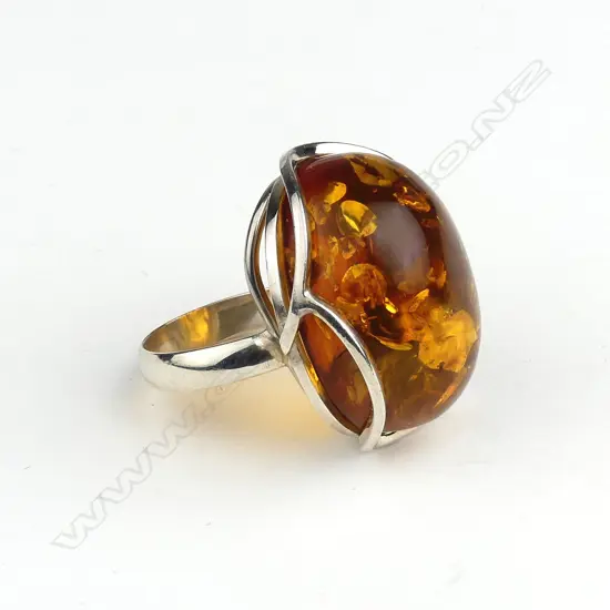 A large polished amber nugget and silver cocktail ring