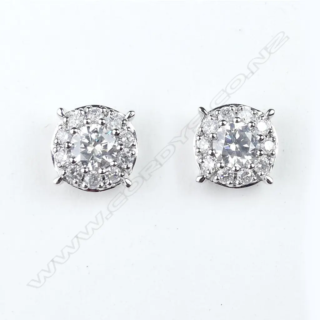 A pair of platinum and diamond halo stud earrings Image 1++
