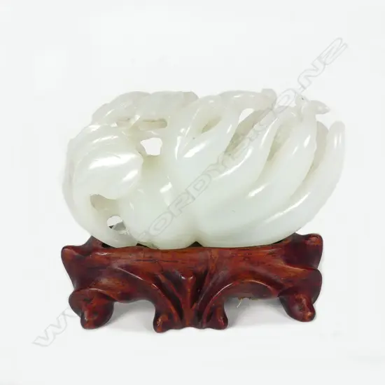 A Chinese pale green jade handling piece carved as a finger citron