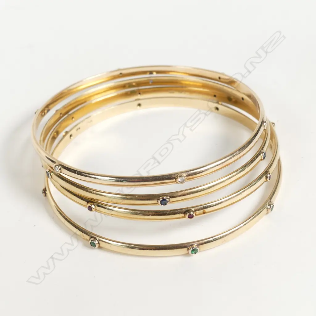A set of four 9ct gold gem set bangles Image 1++