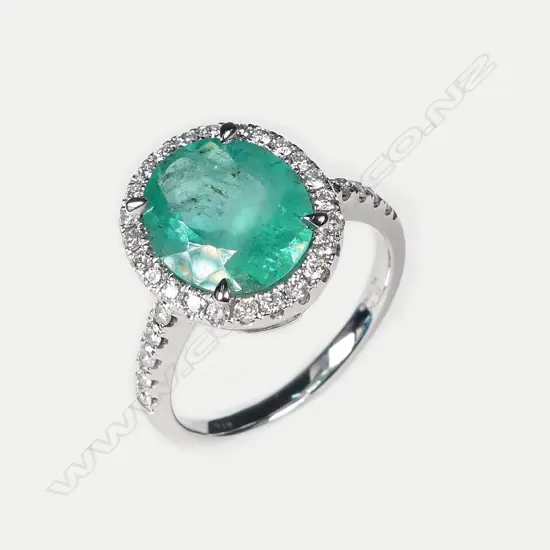 A platinum emerald and diamond ring