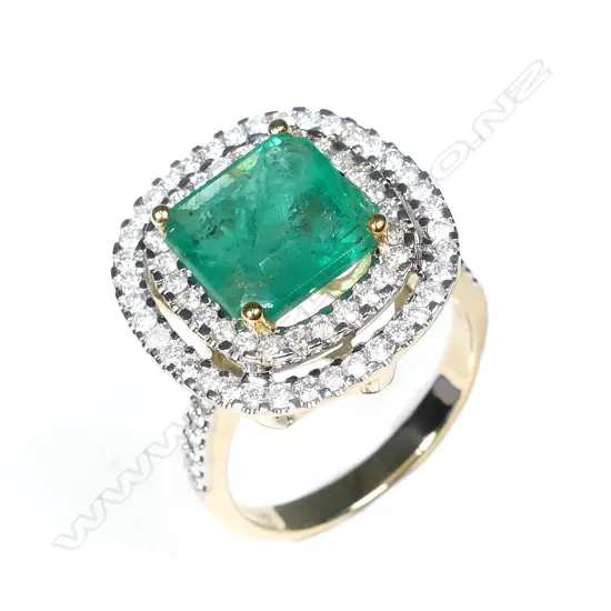 A 14ct gold emerald and diamond double halo ring