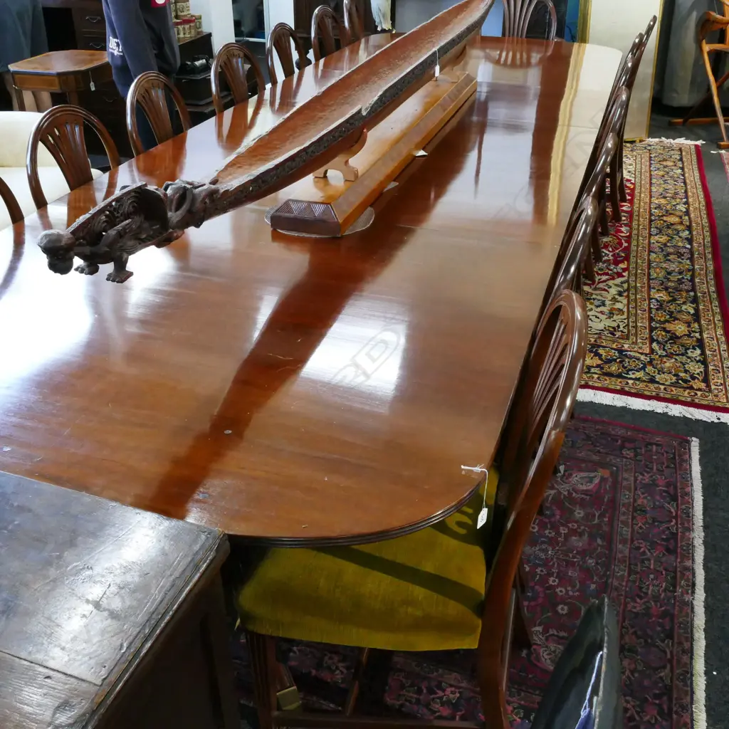 A mahogany banqueting extension Regency style dining table and sixteen Hepplewhite style chairs Image 1++