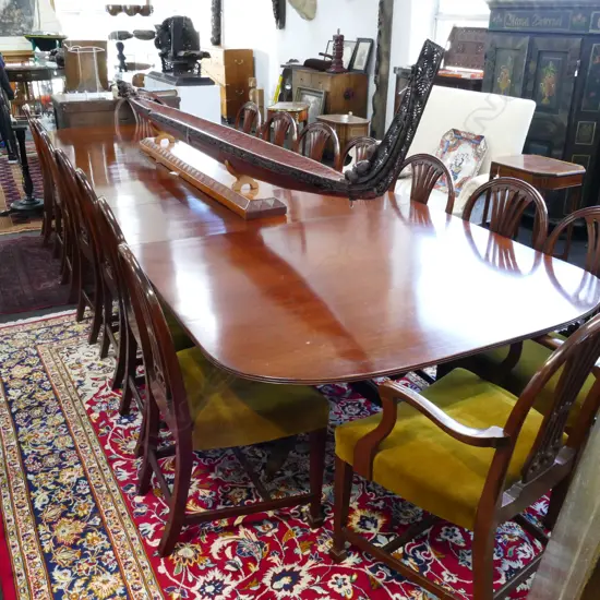 A mahogany banqueting extension Regency style dining table and sixteen Hepplewhite style chairs