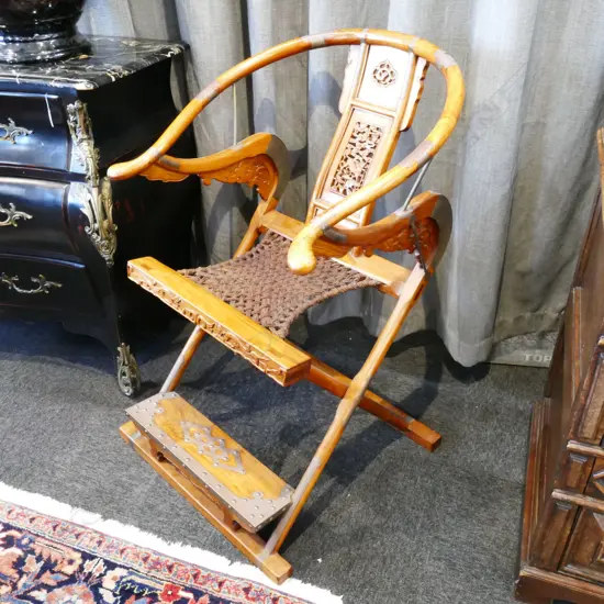 A pair of Chinese hardwood horseshoe-back folding armchairs