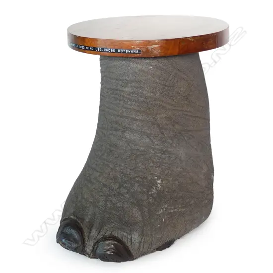 An occasional table fashioned from an elephant foot with fitted wooden top