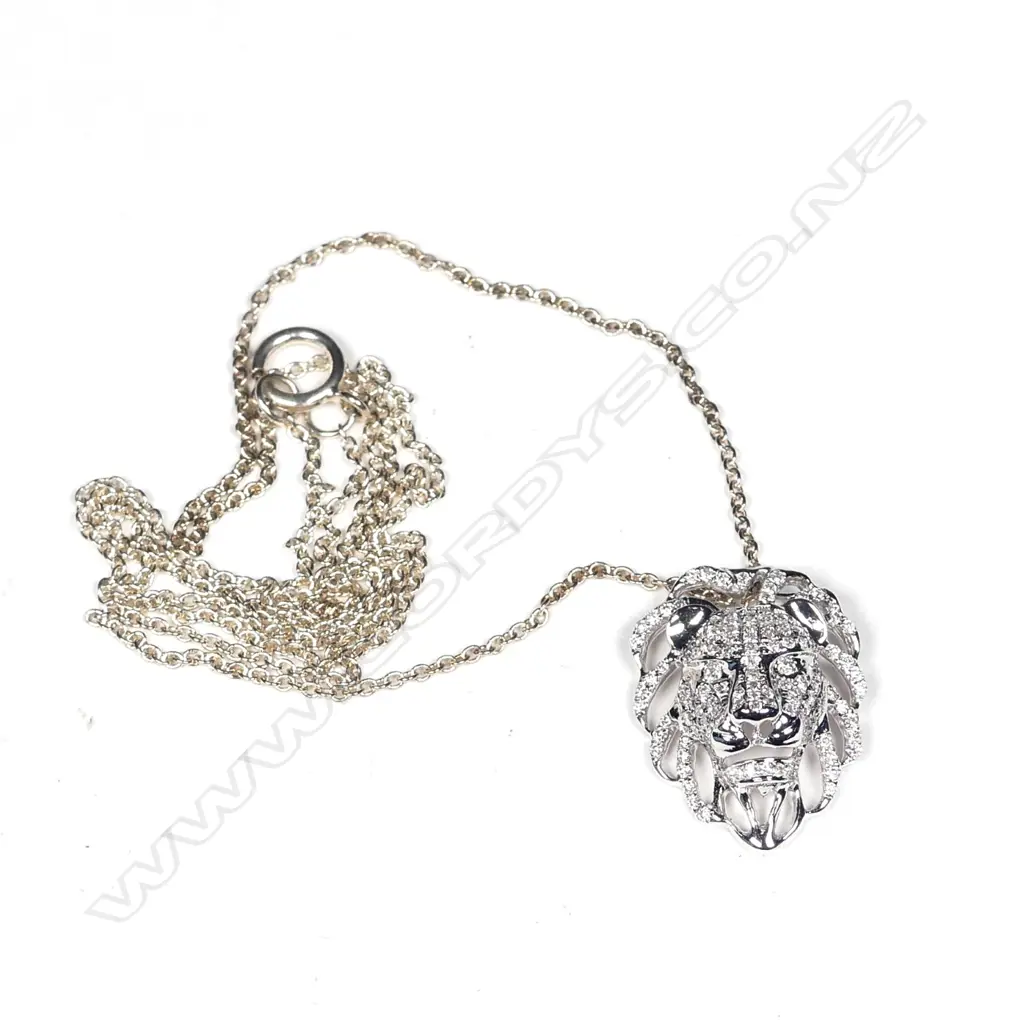 An 18ct. white gold and diamond set lion mask pendant on chain Image 1++