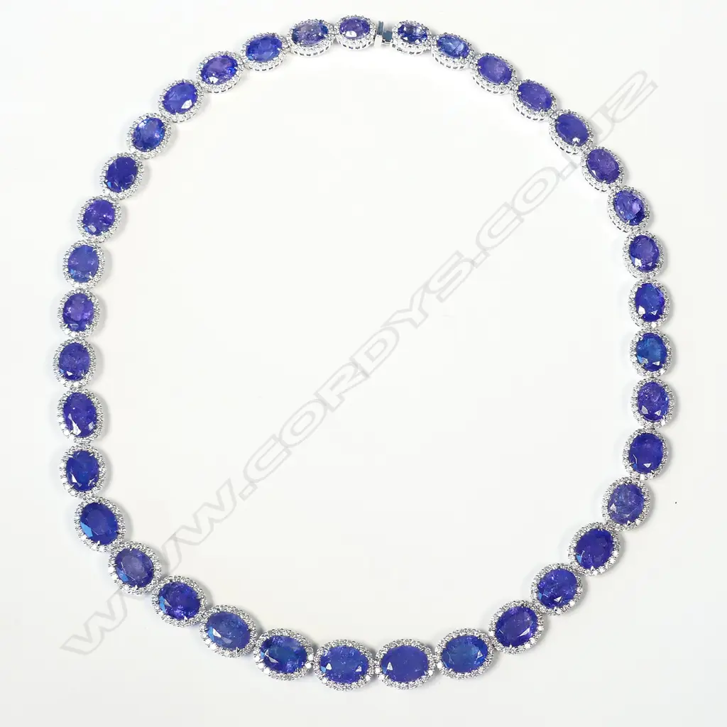 An impressive platinum tanzanite and diamond halo necklace Image 1++