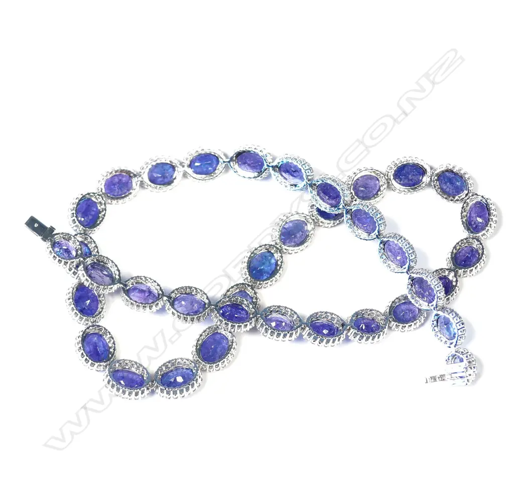 An impressive platinum tanzanite and diamond halo necklace Image 1++