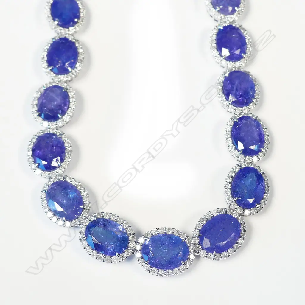 An impressive platinum tanzanite and diamond halo necklace Image 1++