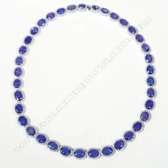 An impressive platinum tanzanite and diamond halo necklace