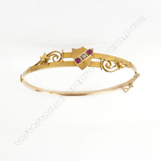 An Edwardian 9ct. gold ruby and diamond hinged bangle