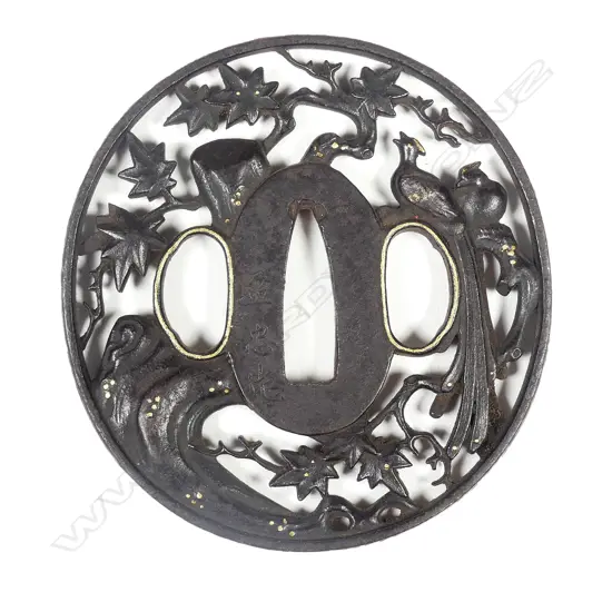 A circular iron tsuba with sculpted filigree design