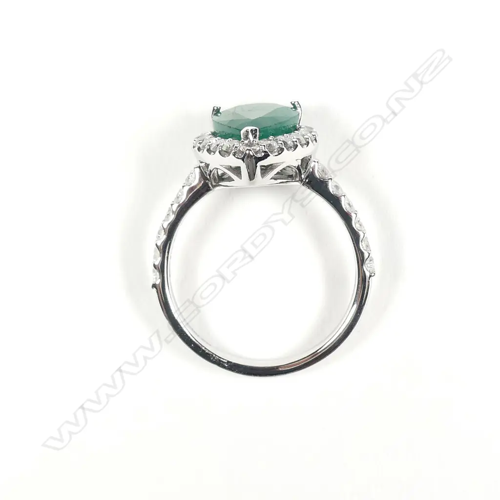 A 14ct white gold emerald and diamond halo ring Image 1++