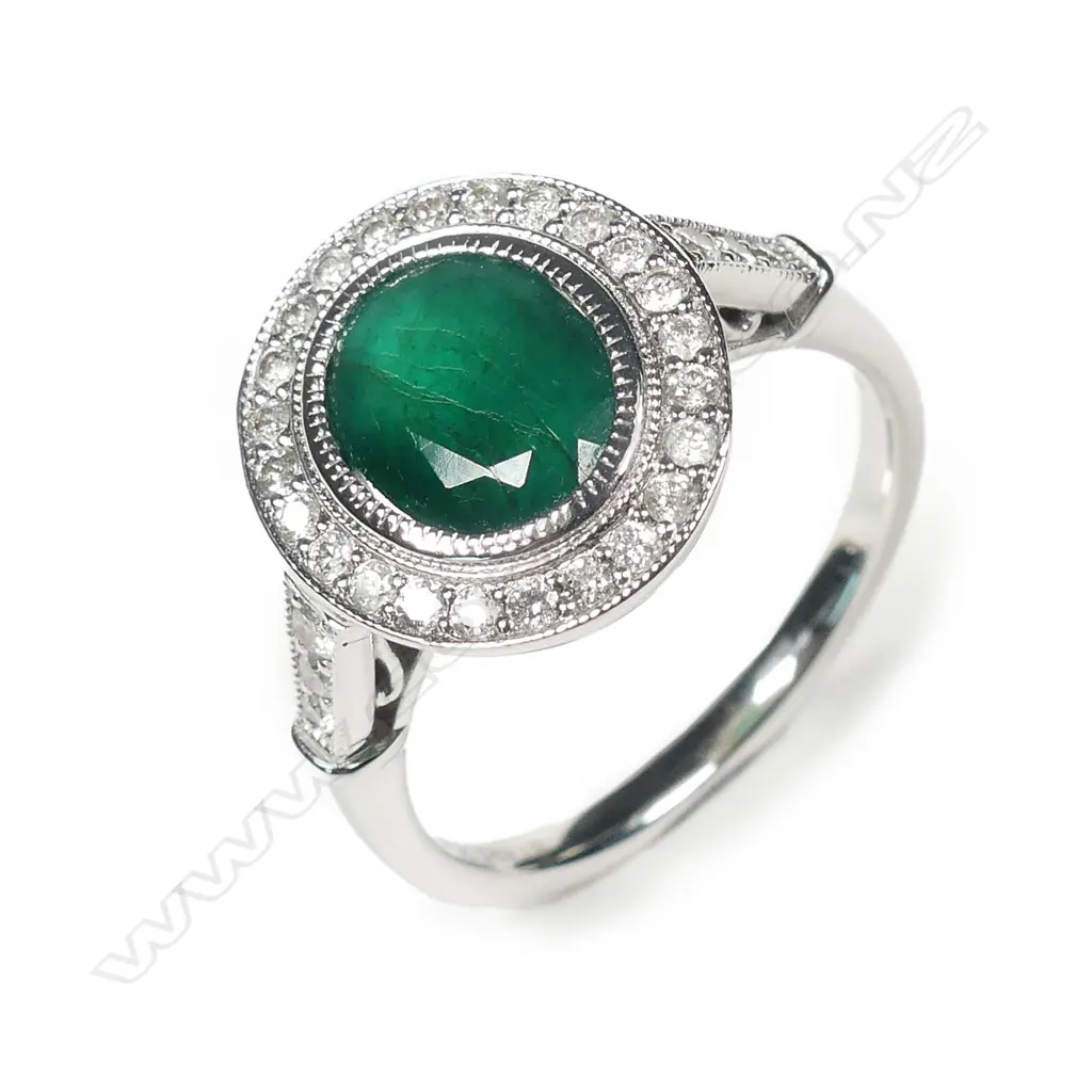 A 14ct white gold emerald and diamond halo ring Image 1++
