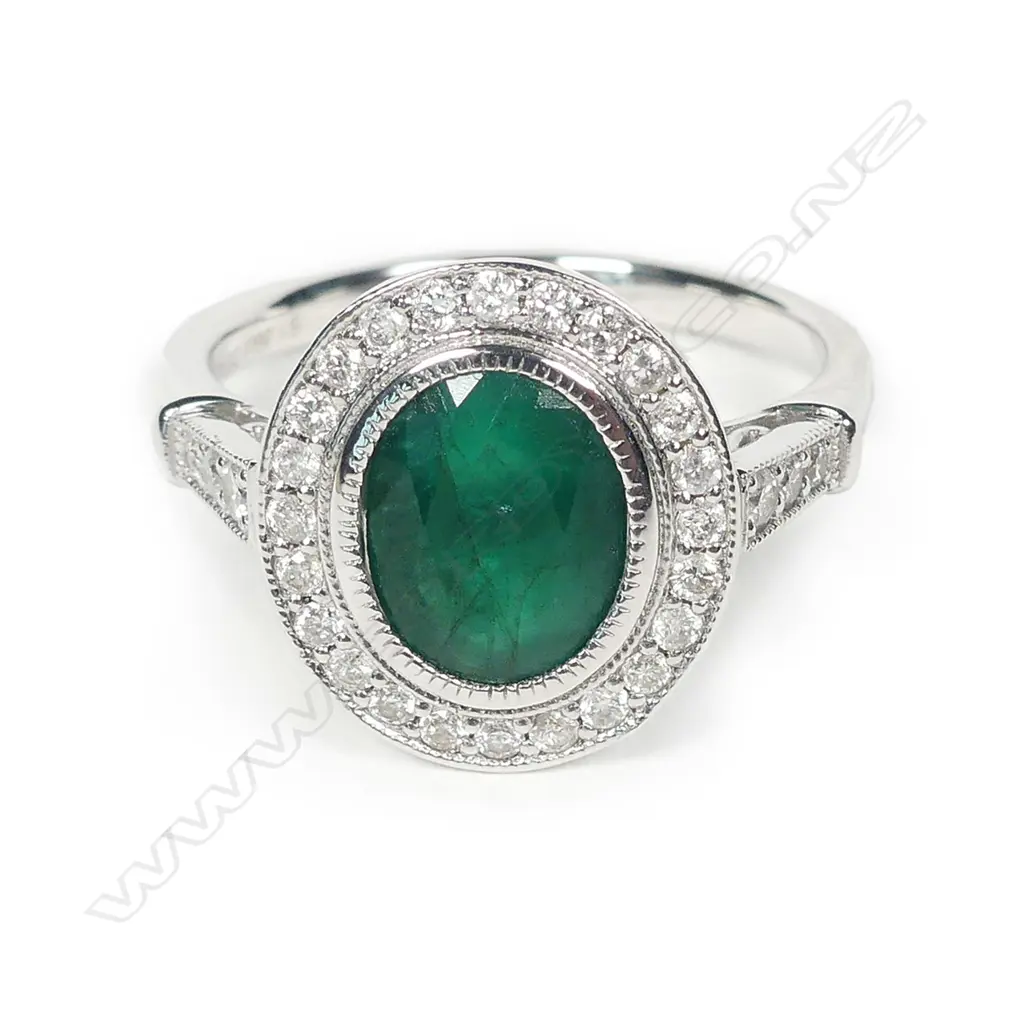 A 14ct white gold emerald and diamond halo ring Image 1++