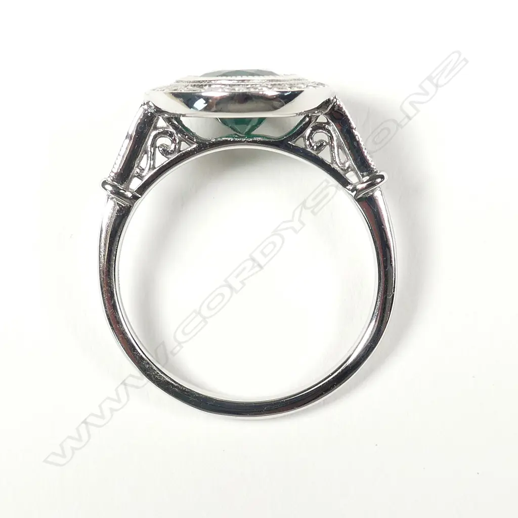 A 14ct white gold emerald and diamond halo ring Image 1++