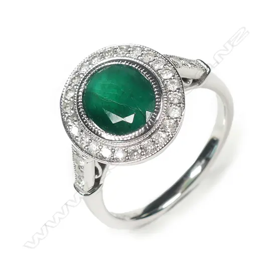 A 14ct white gold emerald and diamond halo ring