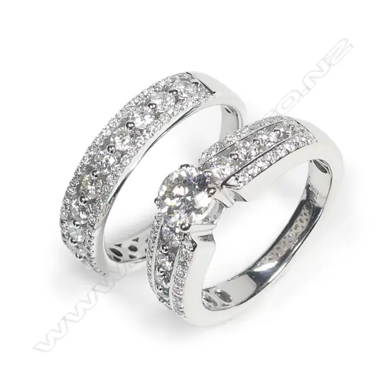 A pair of modern 18ct. white gold and diamond engagement and wedding rings