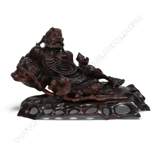 A carved Chinese hardwood reclining Immortal,