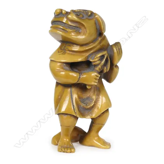 An ivory netsuke of a performer wearing a shishi mask,