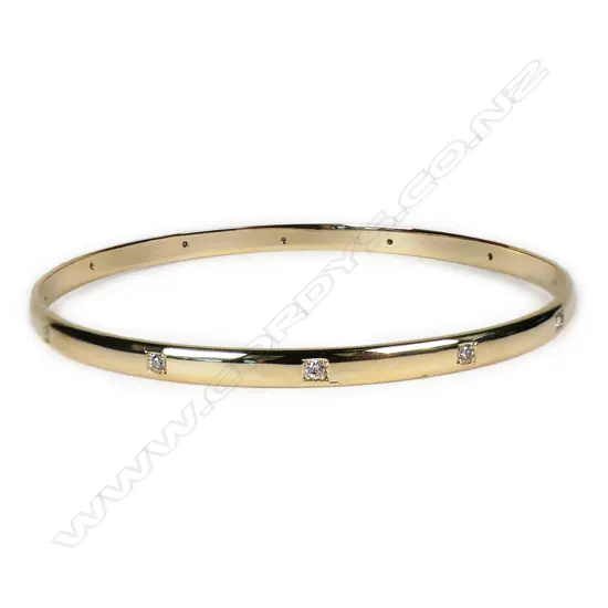 A modern 9ct yellow gold and diamond set bangle,