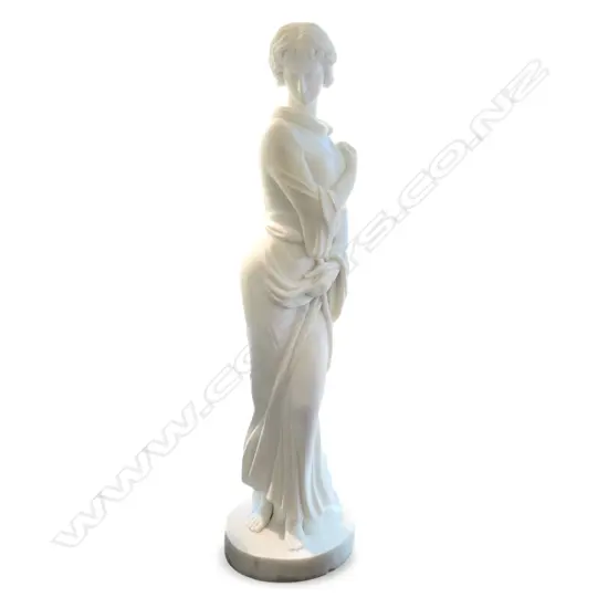 A tall white marble sculpture of a standing woman,