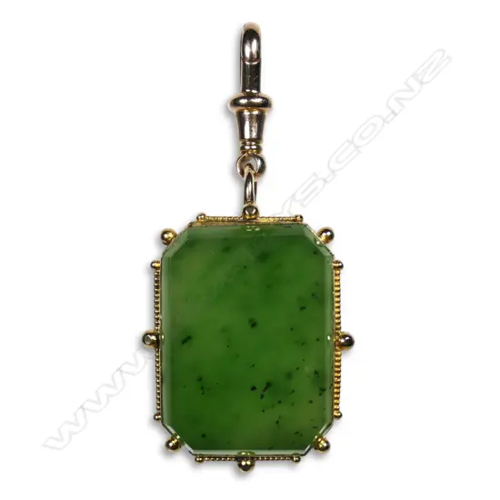 A vintage gold framed pounamu pendant with attached clip,