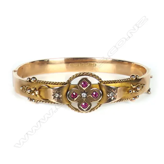 A early 1900s 9ct rose gold diamond and ruby bangle,