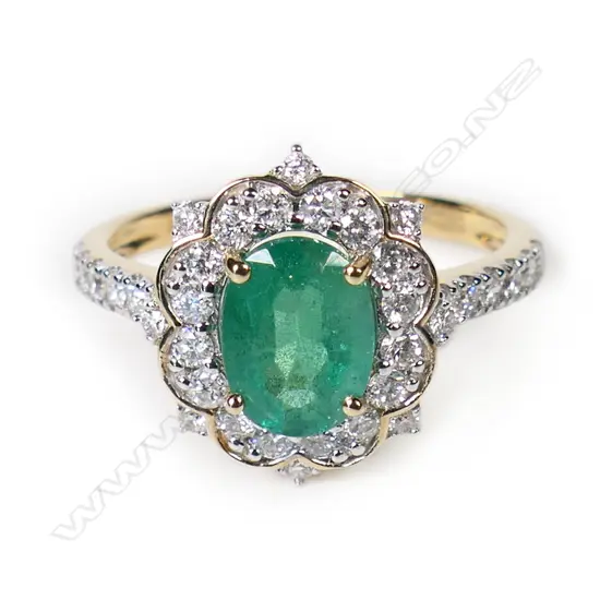 A 14ct gold emerald and diamond halo ring,