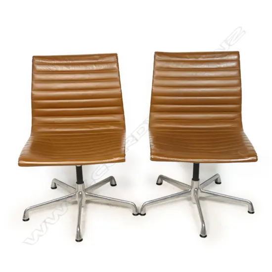 A pair of tan leather Eames conference swivel chairs,