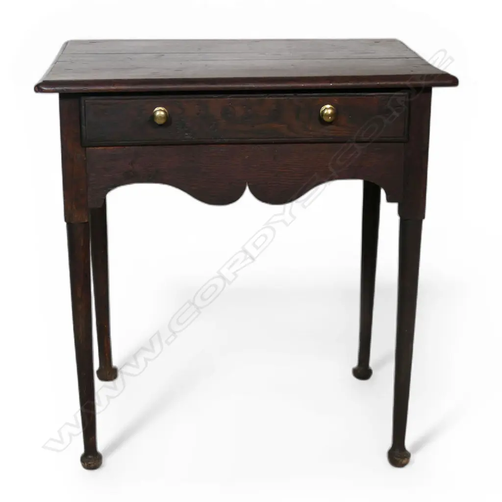 A George III country oak lowboy, single drawer, serpentine shaped frieze. Slender tapered cylindrical legs with pad feet. Top requires attention, some borer. 710 x 525 x 865mm. Provenance: From the estate of Adrian Michael Garrett of Kerikeri. Image 1++