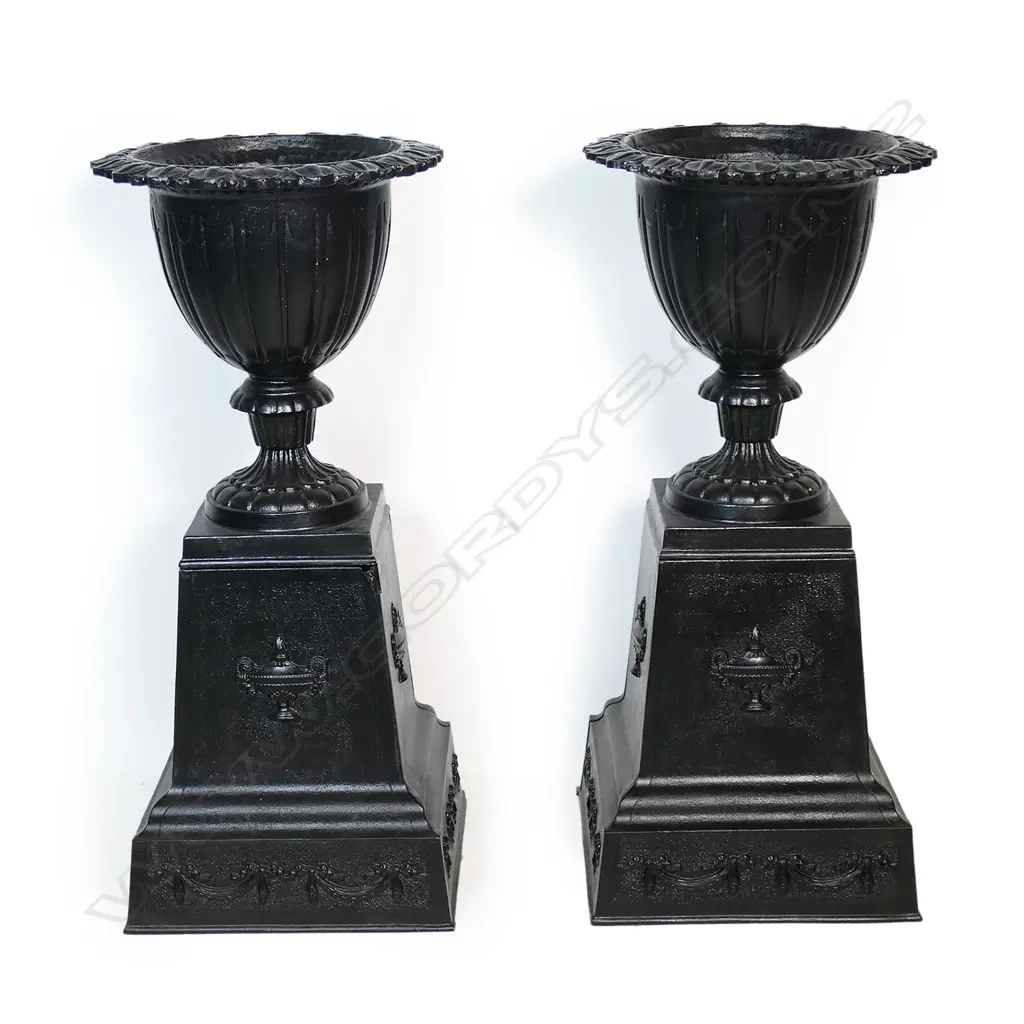 A pair of old refurbished cast iron urns on plinth bases, Image 1++