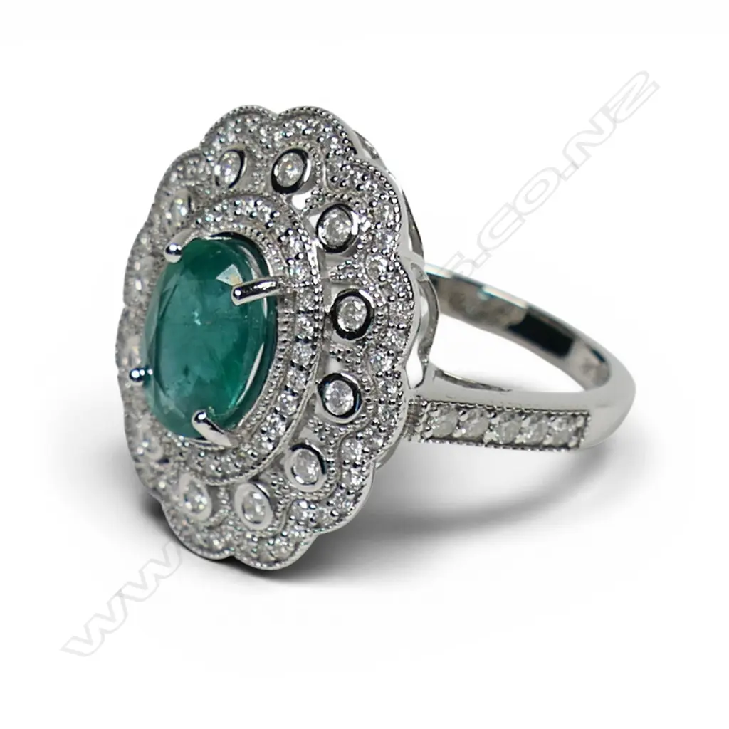 A 14ct white gold emerald and diamond cluster ring, Image 1++