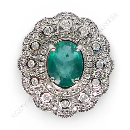A 14ct white gold emerald and diamond cluster ring,