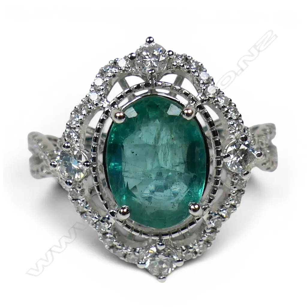 A 14ct white gold emerald and diamond halo ring, Image 1++