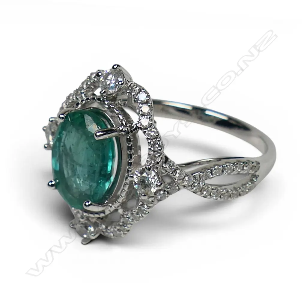 A 14ct white gold emerald and diamond halo ring, Image 1++