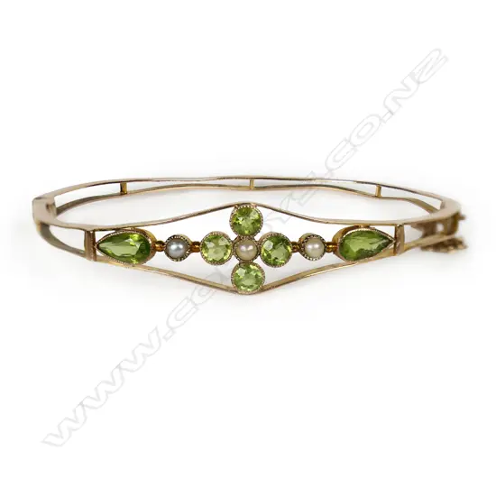 An Edwardian 9ct rose gold peridot and pearl hinged bangle,