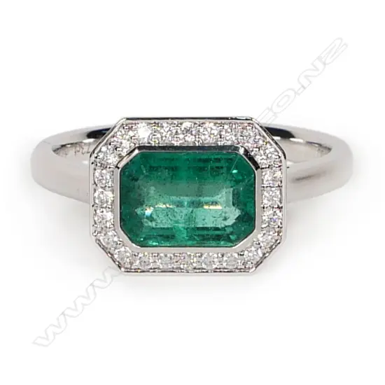 An 18ct white gold emerald and diamond ring,