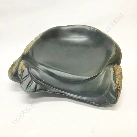 A large dark green pounamu carved boulder bowl