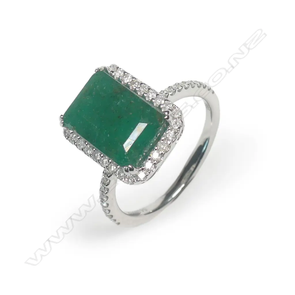 A 14ct white gold emerald and diamond halo ring Image 1++