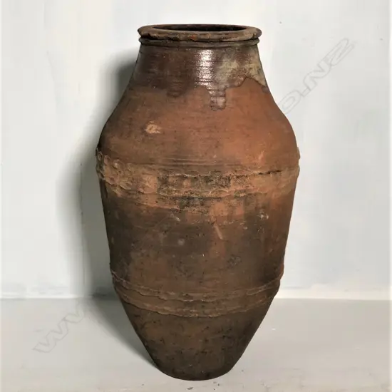 An old European terracotta tall olive oil storage jar