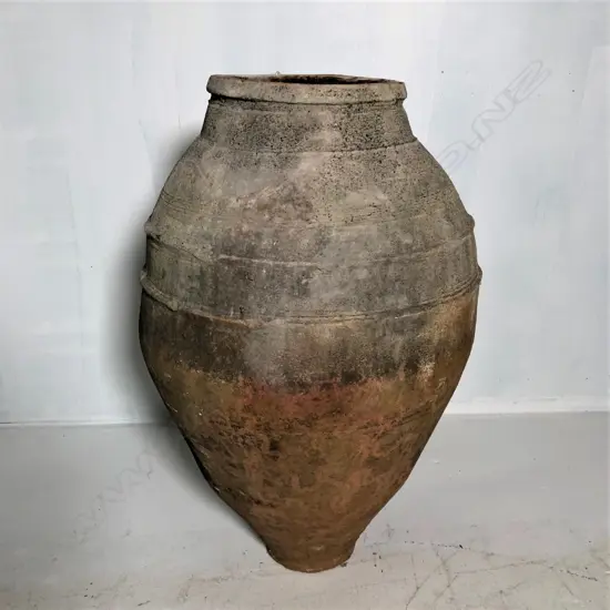 An old European terracotta tall olive oil storage jar