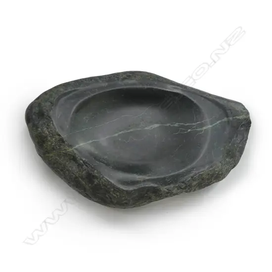 A large dark green pounamu carved boulder bowl