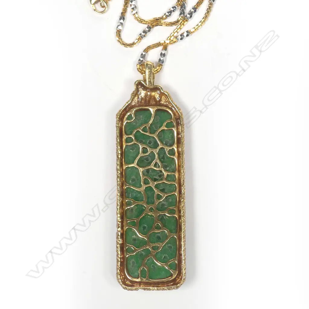 An impressive green jadeite carved pendant in 18ct. yellow gold frame highlighted with diamonds Image 1++