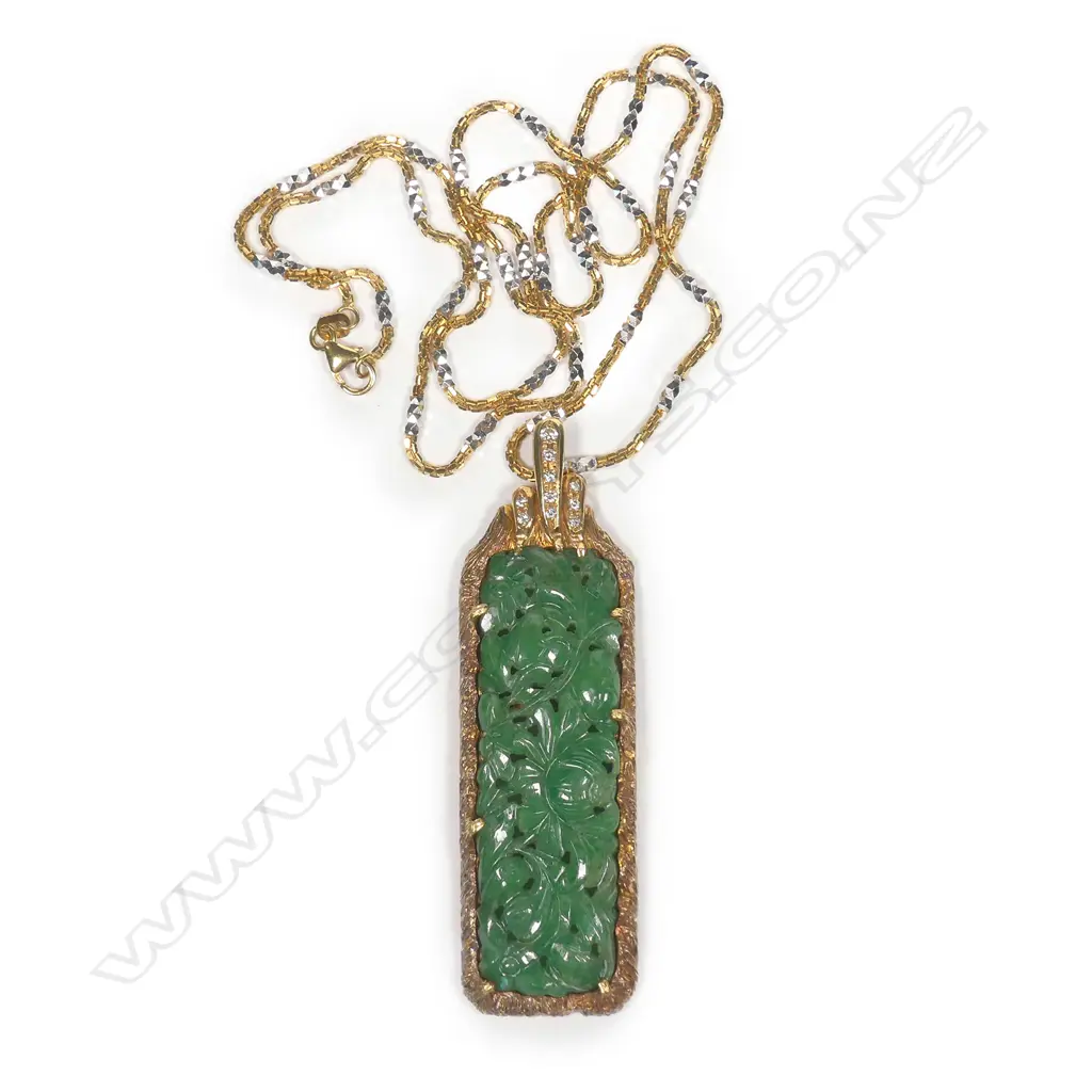An impressive green jadeite carved pendant in 18ct. yellow gold frame highlighted with diamonds Image 1++
