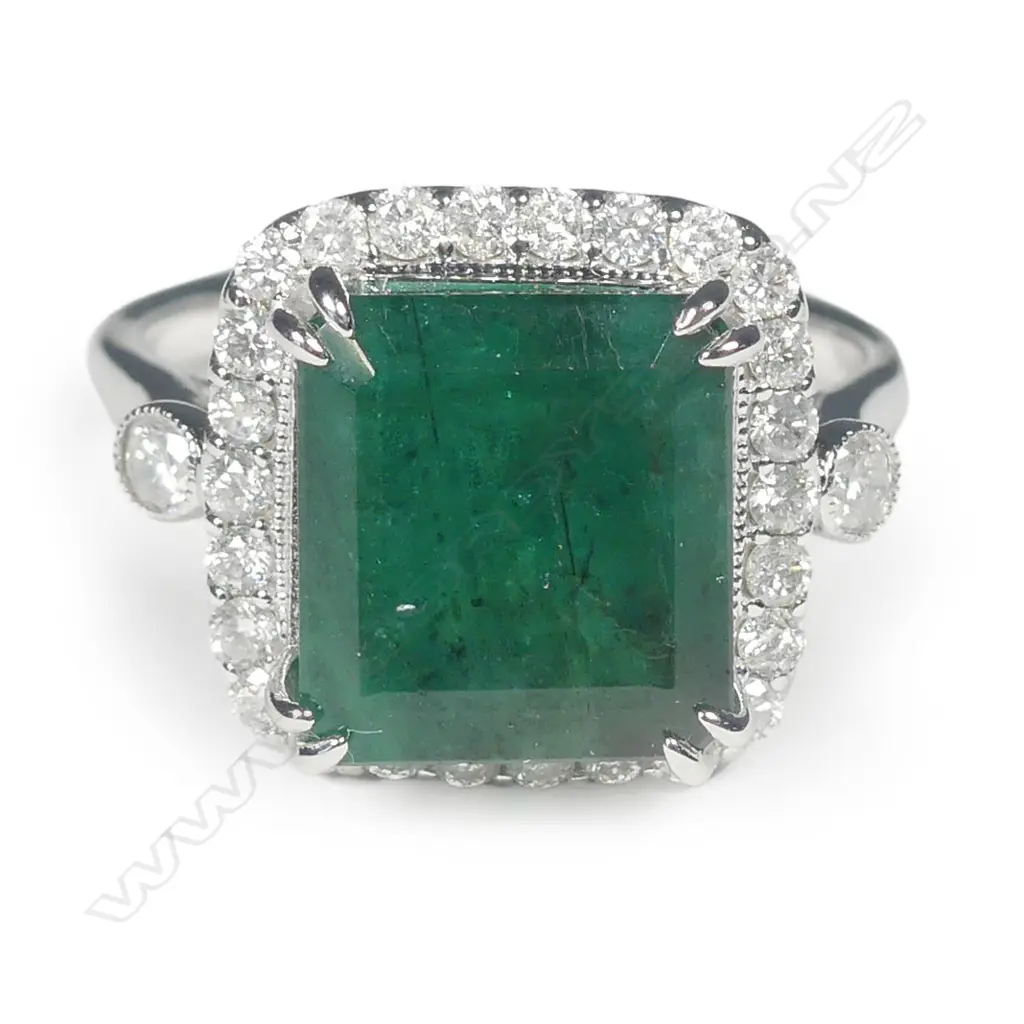 A 14ct white gold emerald and diamond halo ring Image 1++