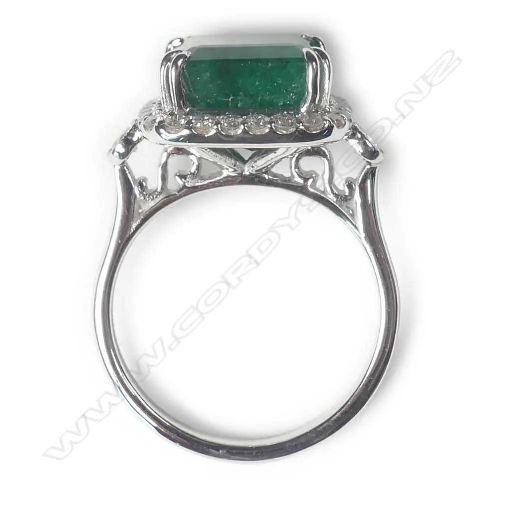 A 14ct white gold emerald and diamond halo ring Image 1++