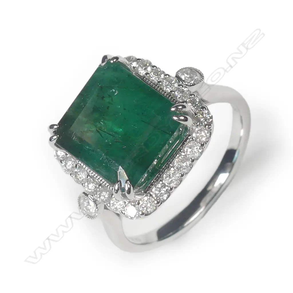 A 14ct white gold emerald and diamond halo ring Image 1++