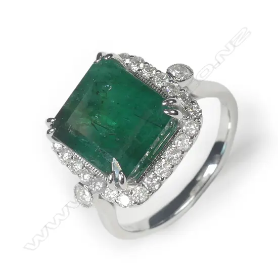 A 14ct white gold emerald and diamond halo ring